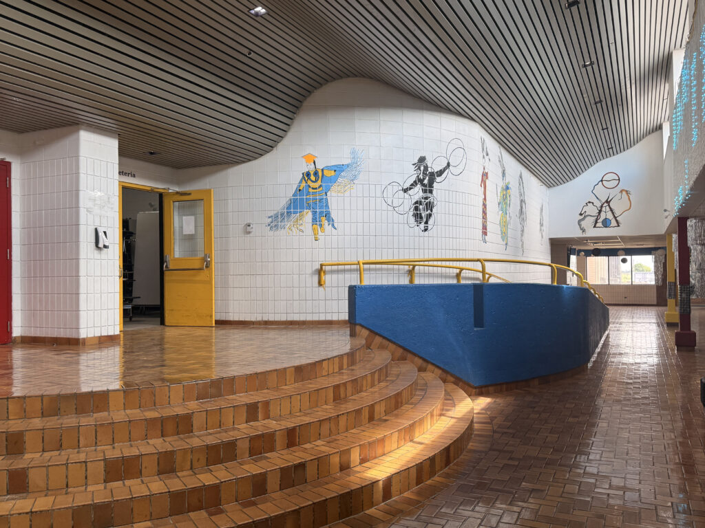 A school hallway with stairs and a ramp.